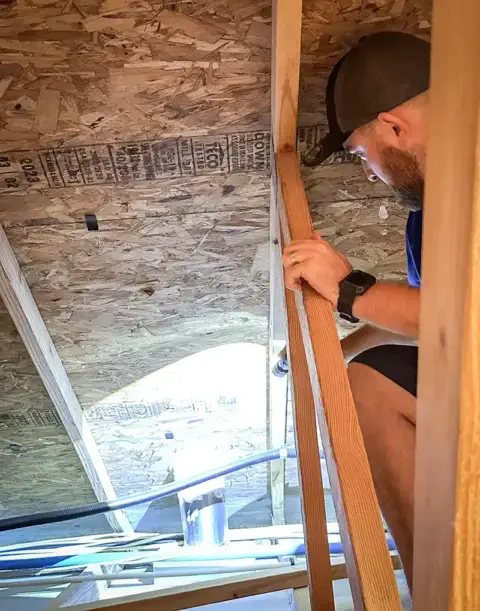 Inspecting the attic to ensure everything is up to code.