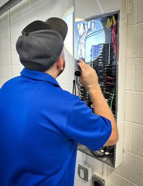 Jordan Drew inspects a home's electrical panel.
